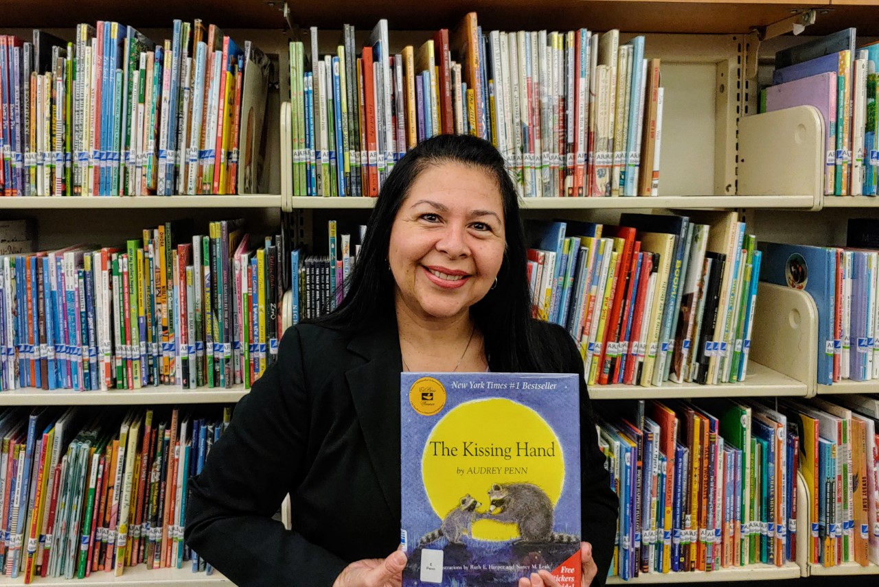 A woman stands in front of a library